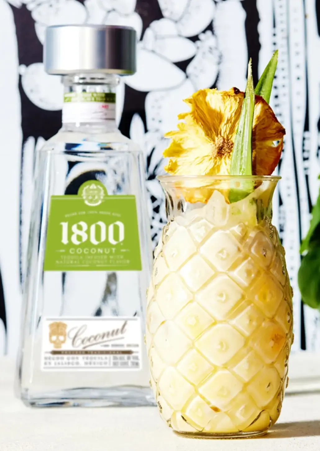 bottle of 1800 coconut and glass of coco colada